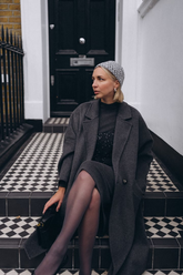 a lady in a grey sequin dress and a grey wool coat
